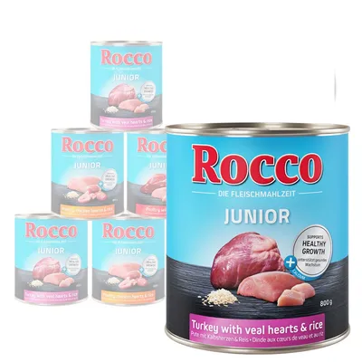Rocco Junior canned dog food, visible flavours: Turkey with veal hearts & rice, Poultry with chicken hearts & rice. 800g tins, label shows meat and rice images, supports healthy growth.