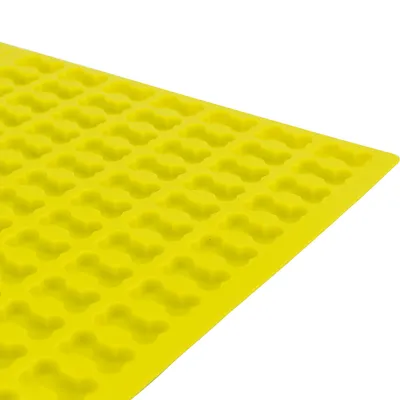 Gul silikoneform med flere små udskæringer i form af hundeben, synlig del af pladen viser gentagne mønstre. Materiale: silikone.