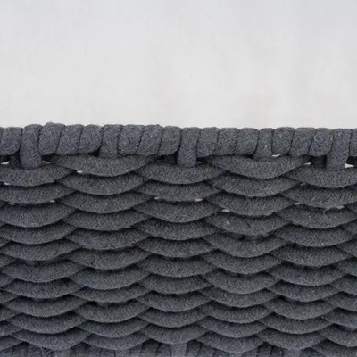 Close-up van grijs, gevlochten textielmateriaal met golvend patroon.