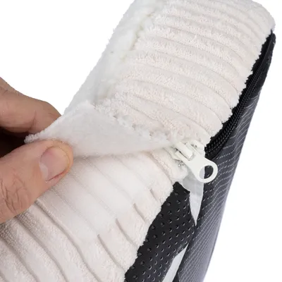 Gros plan sur une housse en tissu blanc à fermeture éclair, montrant la texture côtelée et l’intérieur doux. Partie inférieure noire avec surface antidérapante visible.