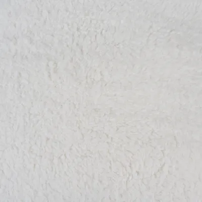 Gros plan sur une surface en tissu blanc à texture pelucheuse, type polaire ou fausse fourrure. Aucun autre élément visible.