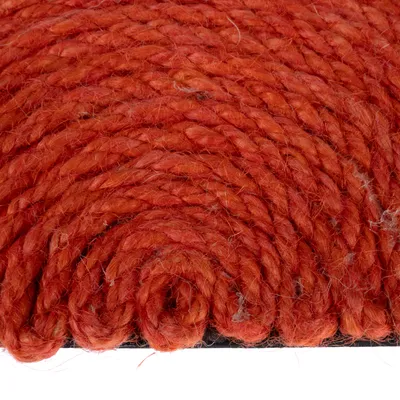 Primer plano de cuerda de sisal roja enrollada en espiral. Estructura del material visible.