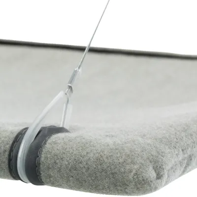 Détail d’un support en tissu gris avec fixation par câble métallique et attache plastique visible sur le coin.