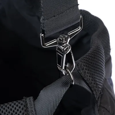 Close-up of a silver carabiner attached to a grey fabric strap with mesh material in the background.