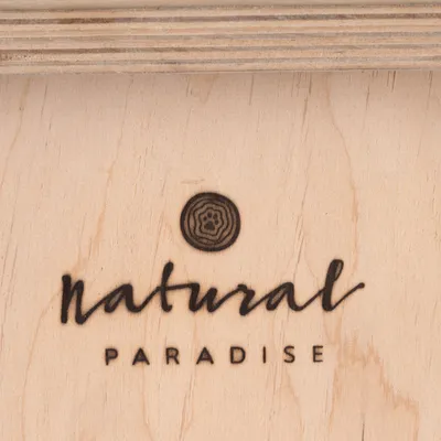 Natural Paradise logo na jasnym drewnie z odciskiem łapy w okręgu.