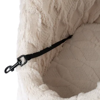 Intérieur d’un panier pour animal en tissu beige à motif, avec sangle noire et mousqueton en métal fixés sur le côté.