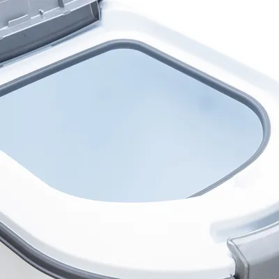 Detailansicht eines weissen Behälters mit transparentem Deckel und grauem Rahmen, geeignet für die Aufbewahrung oder Nutzung im Haushalt.