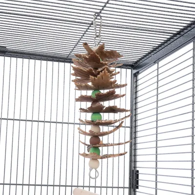 Jouet suspendu pour cage, composé de morceaux de bois et de perles vertes et beiges, accroché par un crochet métallique à la grille supérieure.