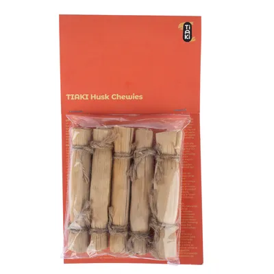 Paquet de bâtonnets à mâcher TIAKI Husk Chewies, 6 pièces en bois ficelées, emballage avec texte anglais visible sur fond orange.