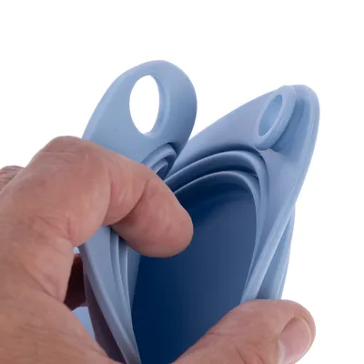 Hand holding foldable blue silicone feeding bowl with hole for attachment.