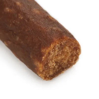 Bližnji posnetek rjavega, prepolovljenega pasjega priboljška z mehko teksturo in vidnim polnilom.