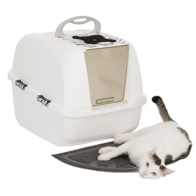 Witte kattenbak met zebrapatroon, transparant klepje en draaggreep. Liggende kat op zwarte mat ervoor.
