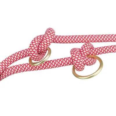Rotes und weiß gemustertes Seil mit zwei Knoten und goldfarbenen Metallringen.