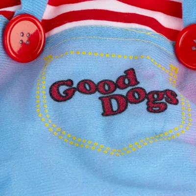 Haft z napisem 'Good Dogs' na jasnoniebieskiej tkaninie, otoczony żółtymi szwami ozdobnymi. Widoczne czerwone guziki i czerwono-białe paski w tle.