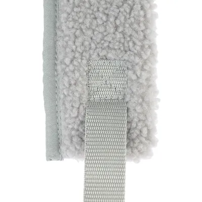 Gros plan sur une sangle en tissu cousue sur une surface grise en matière polaire bouclée, sans marque visible ni texte.