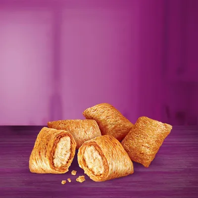 Five baked, filled pastry-style treats with a golden, flaky exterior and visible filling, displayed on a purple surface.