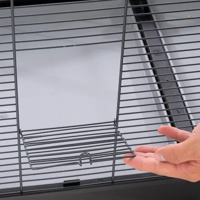 Hand showing the opening of a metal mesh door with sliding lock, suitable for cages or enclosures.