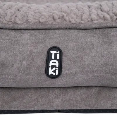 Tiaki-logo op grijze stof met zachte, gestructureerde oppervlakte.