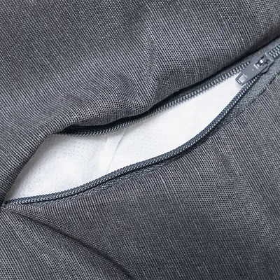 Close-up of a grey cover with zip showing a white padded inner filling.