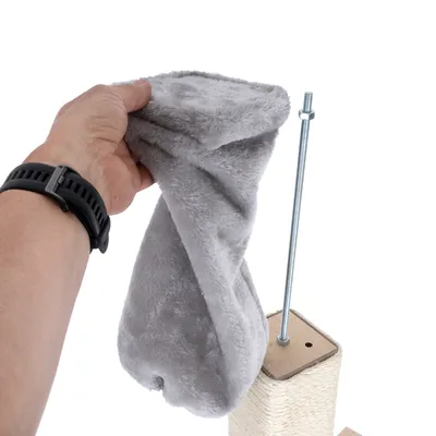 Instrucciones de montaje: mano sostiene funda de tela gris, junto a barra metálica y parte de rascador con orificio para tornillo visibles.