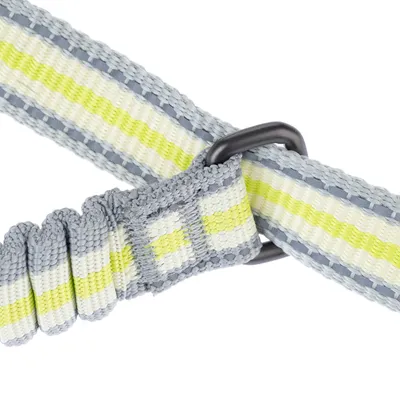 Közelkép egy szürke és sárga csíkos nylon kutyanyakörvről fekete fém karikával.