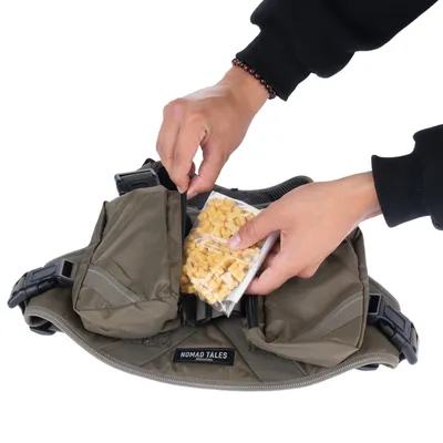 Nomad Tales Gürteltasche mit zwei Reissverschlussfächern, eine Hand entnimmt Hundeleckerlis aus einem Fach.