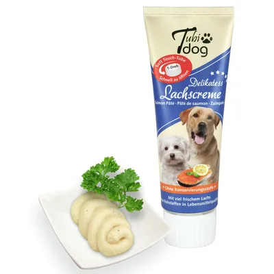Tubi Dog Delikatess Lachscreme пастет за кучета в туба, снимка на продукта с две кучета и текст: Ohne Konservierungsstoffe, Mit viel frischem Lachs. Порция пастет в чиния.