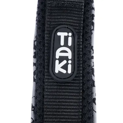 Tiaki logo op zwart stoffen band met grijs patroon.