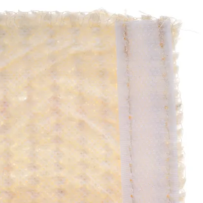 Close-up van een geel, gestructureerd materiaal met een witte rand en zichtbare naden. Materiaalstructuur toont fijne mazen.