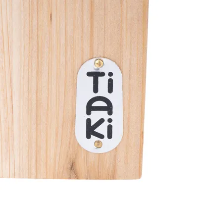 Träyta med metallplakett, med texten 'TAKi'.