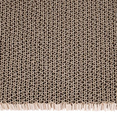 Surface en carton ondulé vue de près, structure alvéolée visible, matériau utilisé pour griffoirs ou accessoires pour animaux.