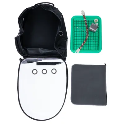 Sac à dos noir avec façade transparente à trois trous, plateau vert avec grille et accessoires, coussin gris. Tous les éléments sont visibles séparément sur fond blanc.