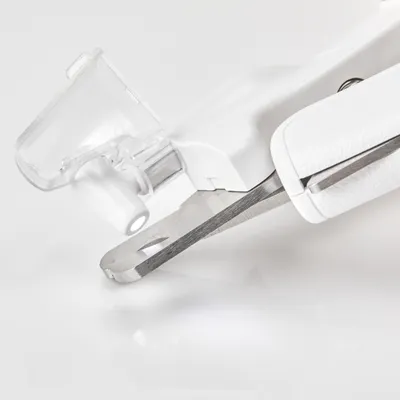Nahaufnahme einer weissen Nagelzange mit transparentem Schutzaufsatz und Edelstahlklinge.