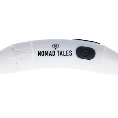 Nomad Tales Schriftzug auf weissem Produkt mit schwarzem Ein-/Ausschalter und Pfeilsymbol.