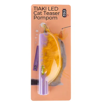 Tiaki LED Cat Teaser Pompom, legetøj med gule fjer og LED-lys, emballagen viser produktoplysninger.