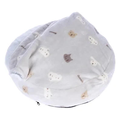Coussin rond en tissu polaire gris clair avec motifs de têtes d’animaux beige et marron, rabat partiellement fermé sur le dessus, fermeture éclair visible à la base.