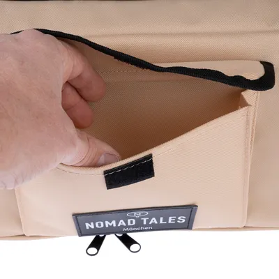 Nomad Tales torba z rzepem i wewnętrzną kieszenią, beżowa. Ręka pokazuje funkcję kieszeni.