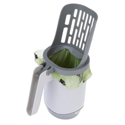 Pala gris con contenedor de residuos integrado y bolsa de basura verde, adecuada para la fácil eliminación de desechos de mascotas.