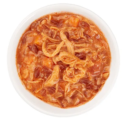 Bol de nourriture humide avec morceaux effilochés et sauce visible, sans marque ni texte apparent.