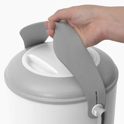 Hand lifts the grey handle of a white container with lid, showing the carrying function of the product.