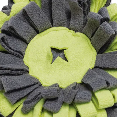 Detailaufnahme eines grauen und grünen Schnüffelteppichs aus Fleece mit sternförmiger Öffnung in der Mitte.