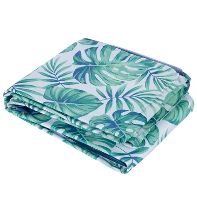 Złożona mata z tropikalnym wzorem liści w zielonym i białym kolorze.