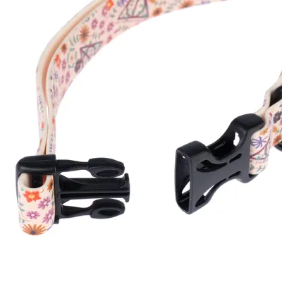 Nahaufnahme eines Halsbandverschlusses mit Blumenmuster und schwarzem Kunststoffclip.