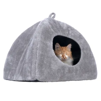 Grey, triangular cat house made of soft fabric with an opening. An orange and white cat is sleeping inside.