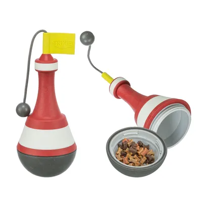 Jouet distributeur Trixie en plastique rouge, blanc et noir avec drapeau jaune, compartiment ouvert montrant des friandises pour animaux. Marque Trixie visible sur le drapeau.