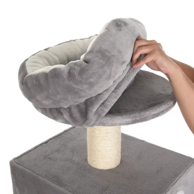 Arbre à chat gris avec griffoir en sisal, main soulevant un coussin amovible en tissu doux sur la plateforme supérieure. Coussin et base recouverts de tissu peluche.