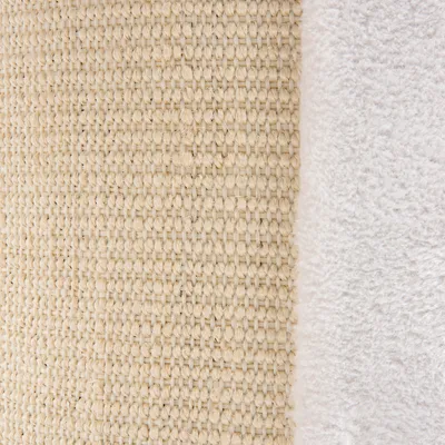 Detalj površine od prirodnog tkanog materijala (sisal) uz bijelu mekanu tkaninu. Prikaz teksture i materijala proizvoda.