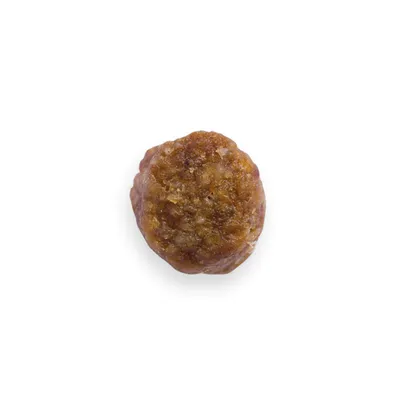 Närbild av ett brunt, köttliknande snacks i rund form. En enskild bit synlig.