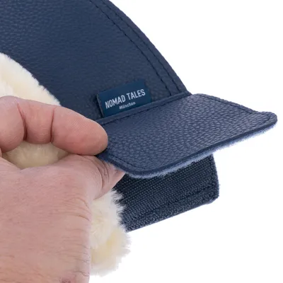 Étiquette visible sur un produit en similicuir bleu avec inscription : NOMAD TALES München. Partie intérieure en tissu peluche beige.