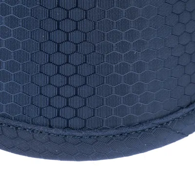 Gros plan sur un tissu bleu à motif hexagonal, couture visible en bas de l’image. Matière textile uniquement.